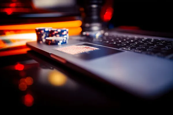 A woman smiling while playing online games on her laptop, surrounded by neon casino elements, showcasing CB44’s diverse game collection.