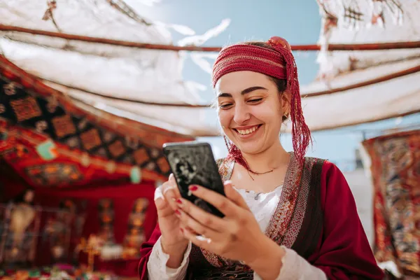 A player using their smartphone during a festive local event, representing CB44’s fully mobile-friendly casino.